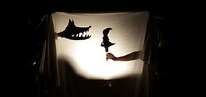 Photo de marionettes (le petit chaperon rouge et le loup) en ombre chinoise.