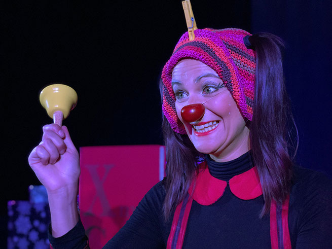 Le clown secoue une cloche jaune