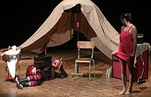 Photo spectacle. La danseuse habillée en rouge regarde le clown souriant allongé par terre.