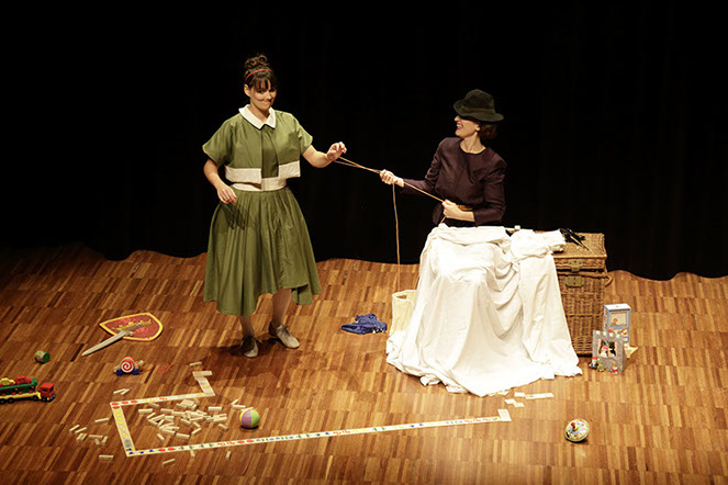 Photo spectacle. La femme au chapeau noir, tient l'autre femme au bout de sa cordelette.