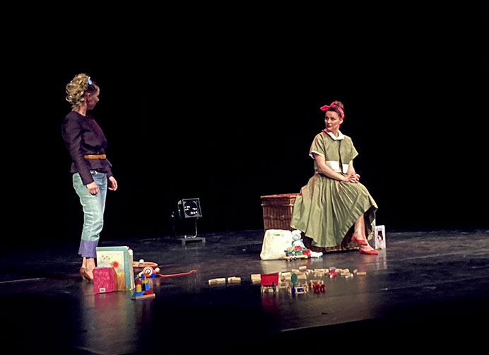 Photo spectacle: deux femmes sur scène, l'une en robe verte, l'autre déguisée en lion.